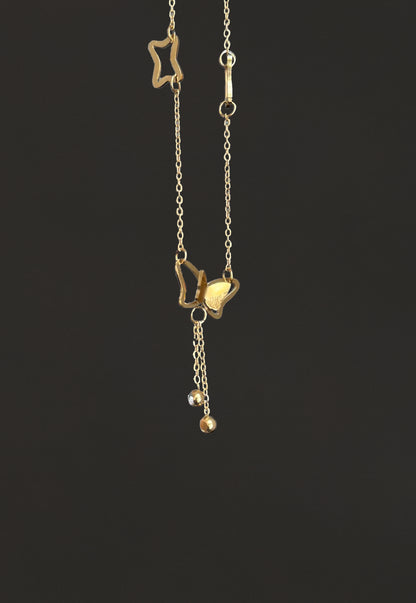 Gold necklace with star and heart pendants on a black background